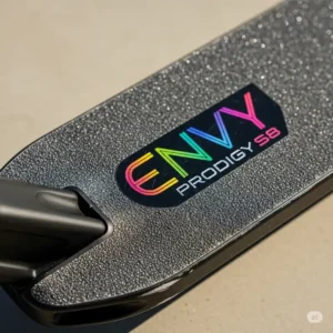 A detailed close-up of the envy scooter Prodigy S8's deck, highlighting the intricate logo and the deck's durable construction.