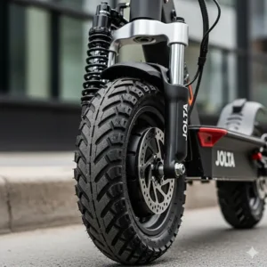 A close-up view of the Jolta electric scooter's durable tires and shock-absorbing suspension system.